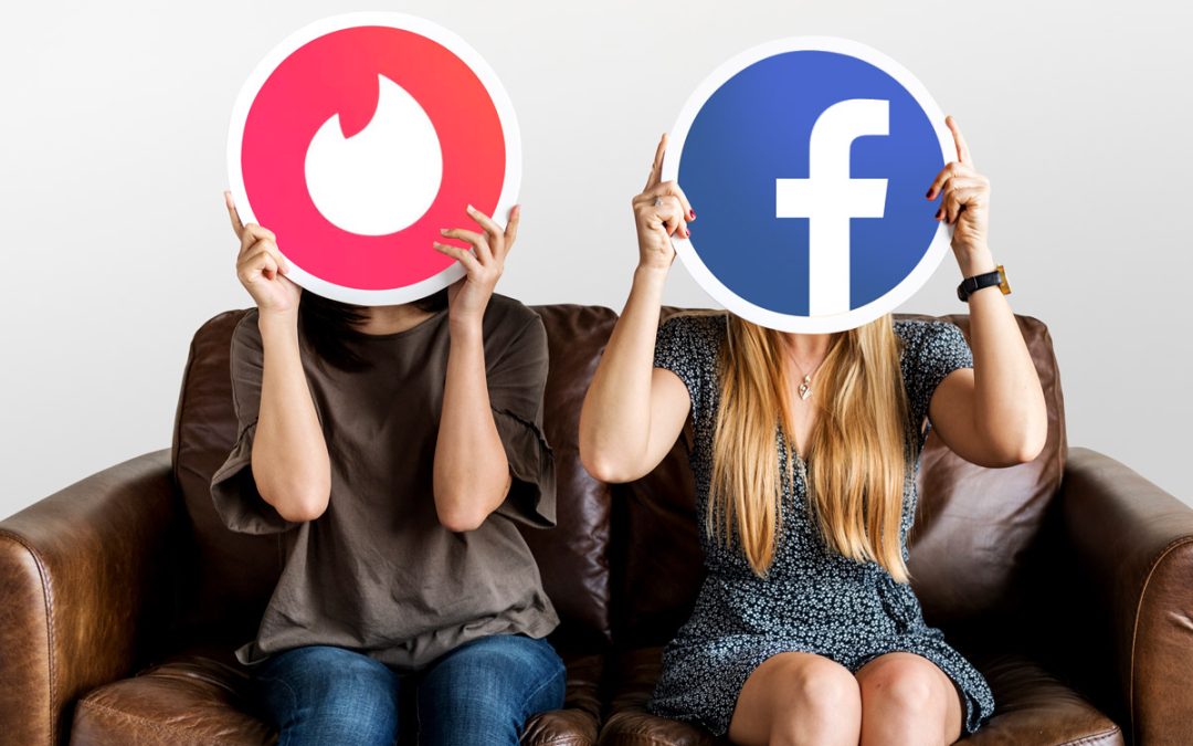 Mujeres con dos logotipos de redes sociales horizontales y verticales (tinder y facebook) tapándose la cara para hablar sobre su definición, características y empleo en la estrategia digital de cualquier negocio.