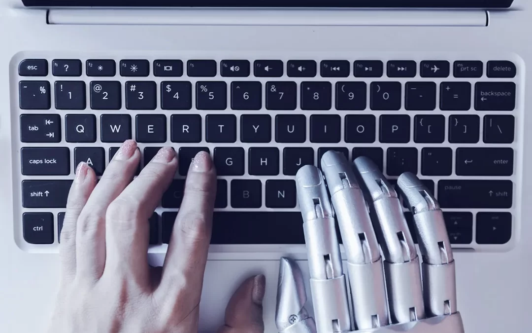 Persona con una mano humana y otra mano robótica escribe en un portátil sobre los consejos de redacción de copywriting.