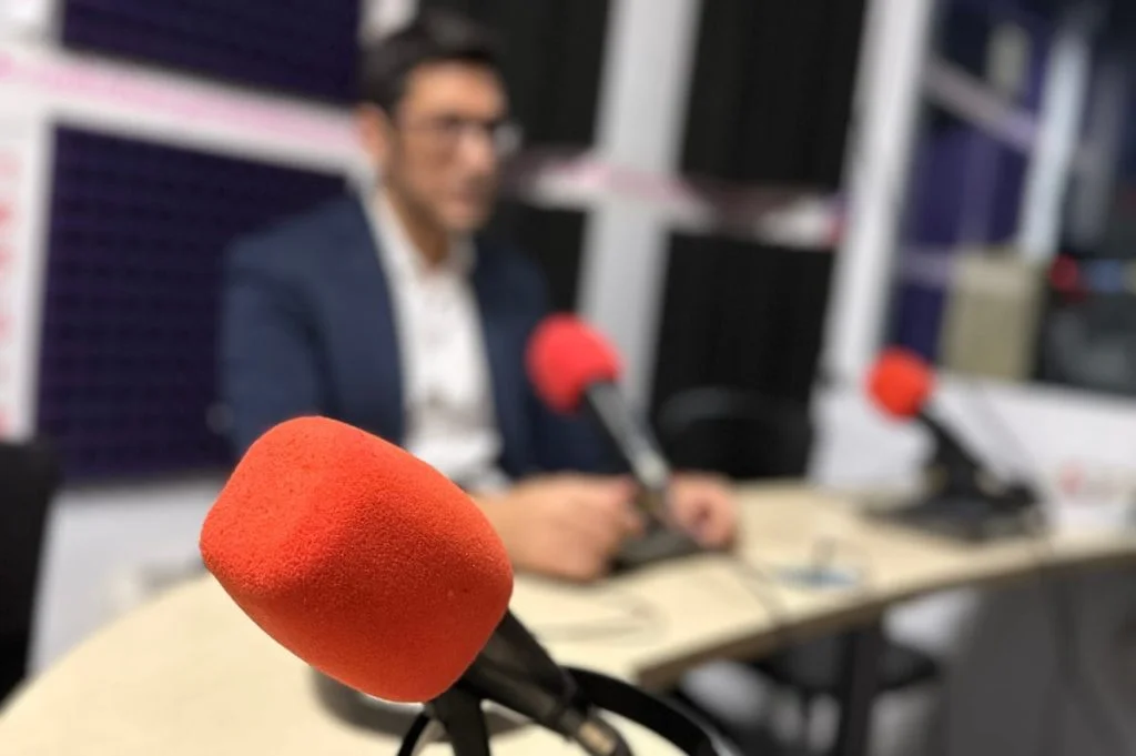 Micrófono abierto en Ràdio Banyeres de Mariola. De fondo, Raúl Carrión en su entrevista sobre el ciclo formativo Banyeres Connecta.
