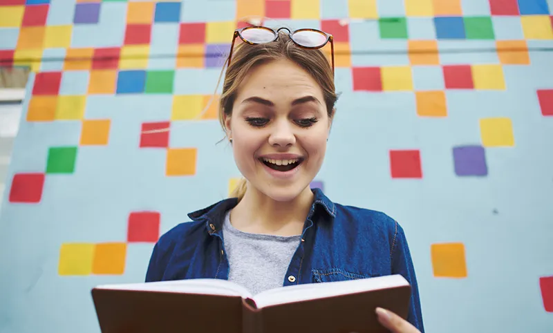 Joven leyendo uno de los libros de marketing digital para principiantes o dummies.